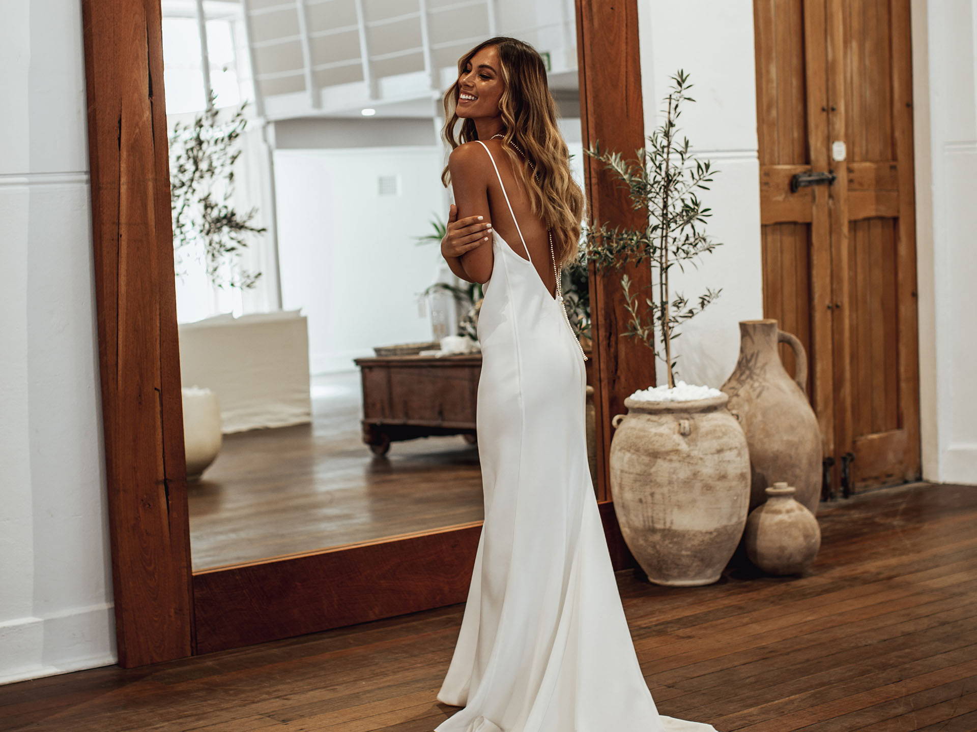 Bride wearing the Grace Loves Lace Summer silk gown with rustic ceramics and large timber mirror