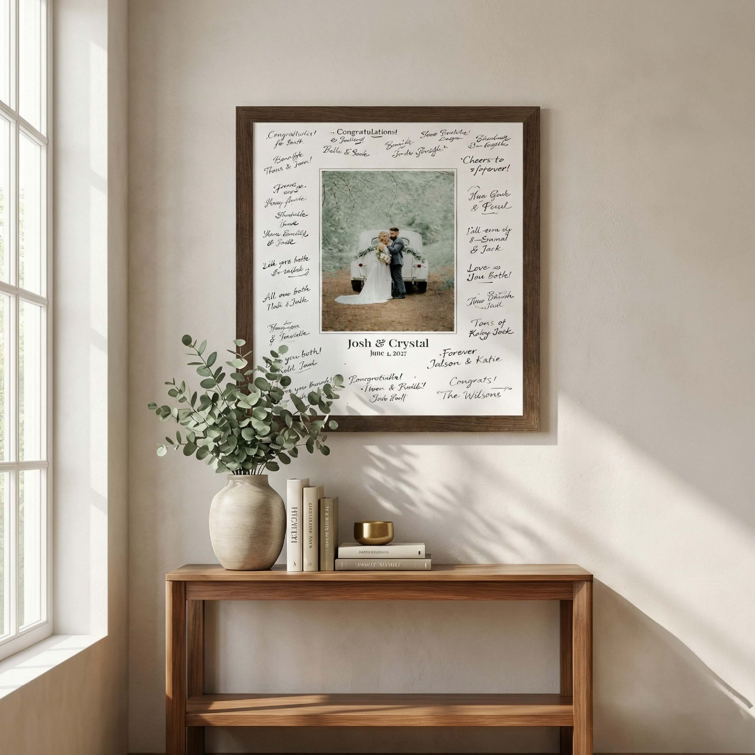 Framed photo with signatures, displayed on a wooden table near a window.