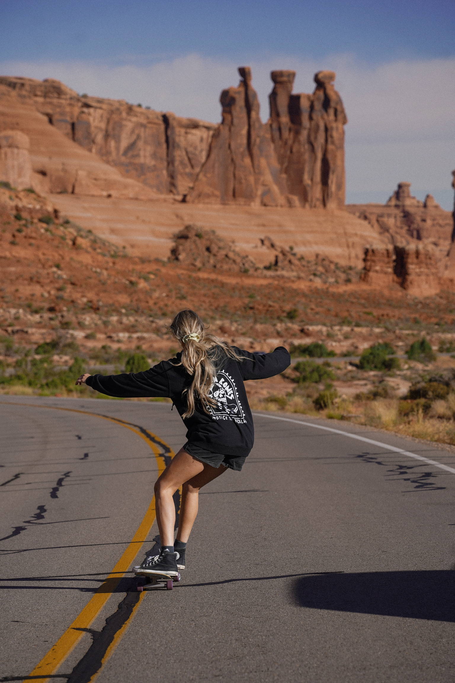 Female skateboarder riding on an empty street in Utah