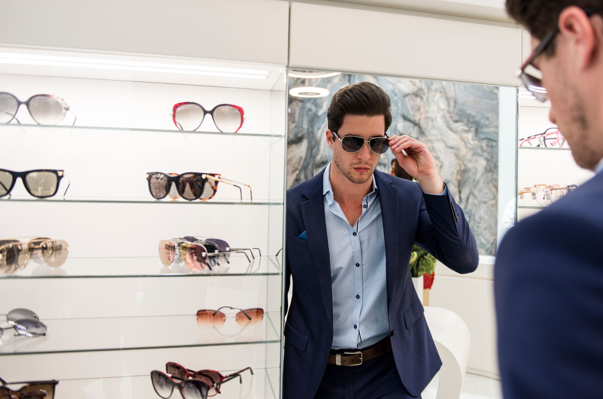Man tries on sunglasses at Designer Eyes in Aventura Mall