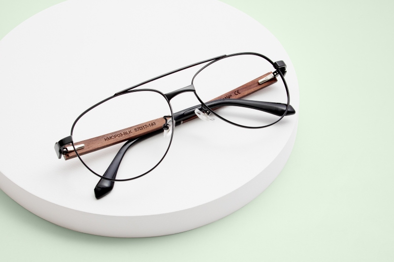 Photo « flat lay » de la paire de lunettes « Purpose Gold », un modèle aviateur noir métallisé, sur un fond vert menthe 
