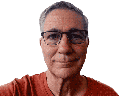 A man with glasses smiling, wearing a red shirt against a black background.
