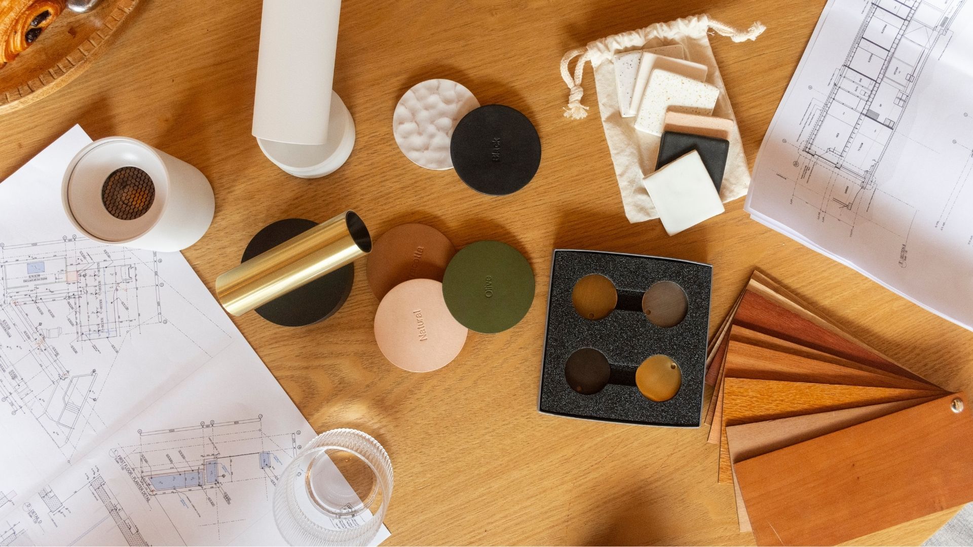 Color samples and design materials arranged on a wooden table during a design consultation.