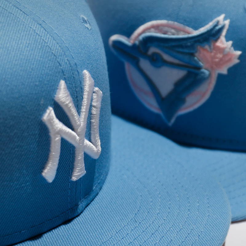 close up of light blue new era hats