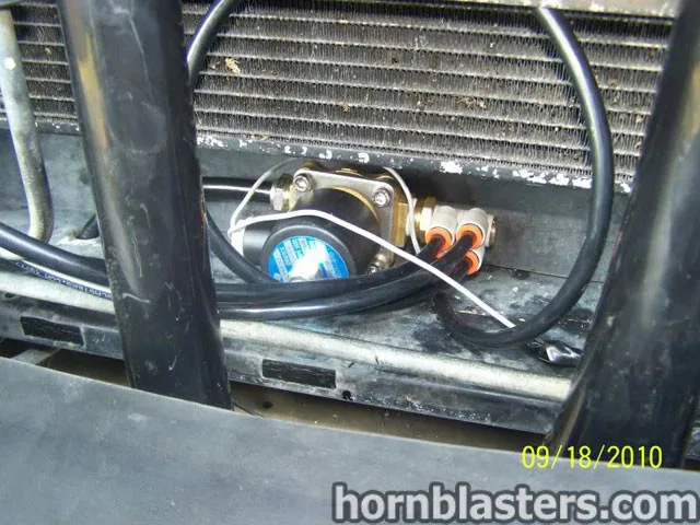 Close-up of train horn wiring and air line routing behind grille