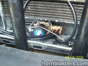 Close-up of train horn wiring and air line routing behind grille
