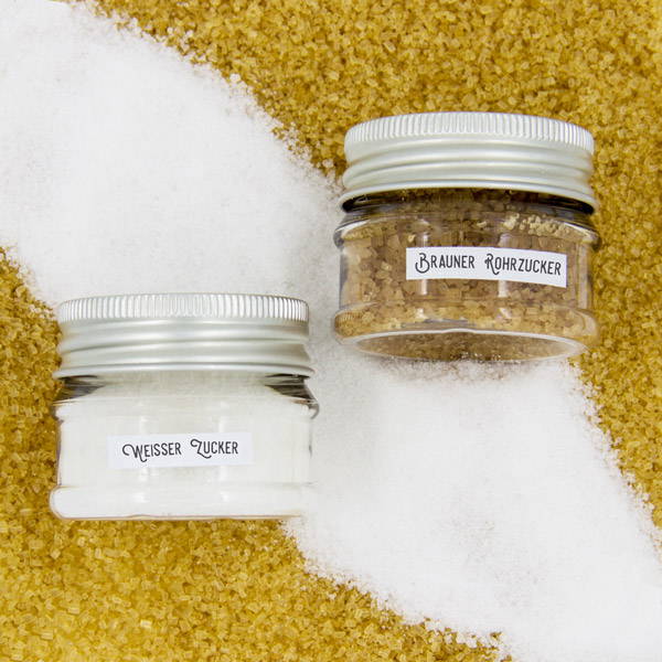 White sugar and brown cane sugar in front of a sugar background