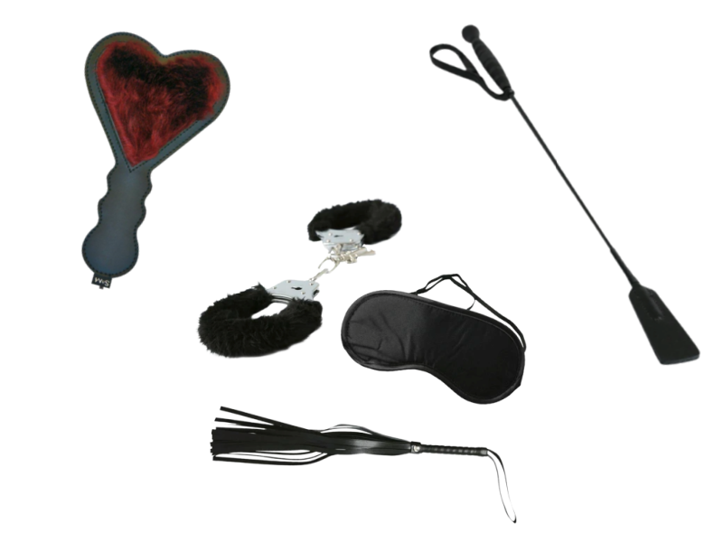 BDSM kit bundle image shows the three items that come in the kit. The image shows a faux fur, heart-shaped paddle, a short riding crop, handcuffs covered in faux fur, a blindfold, and a faux leather flogger.