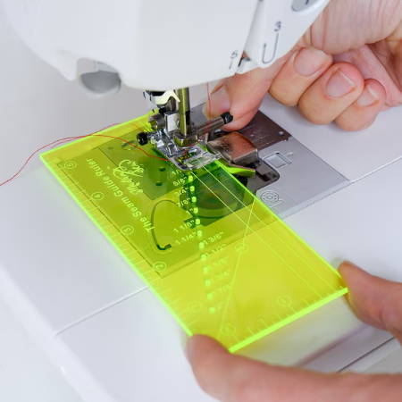 Yellow transparent seam guide ruler on a sewing machine to set the seam allowance