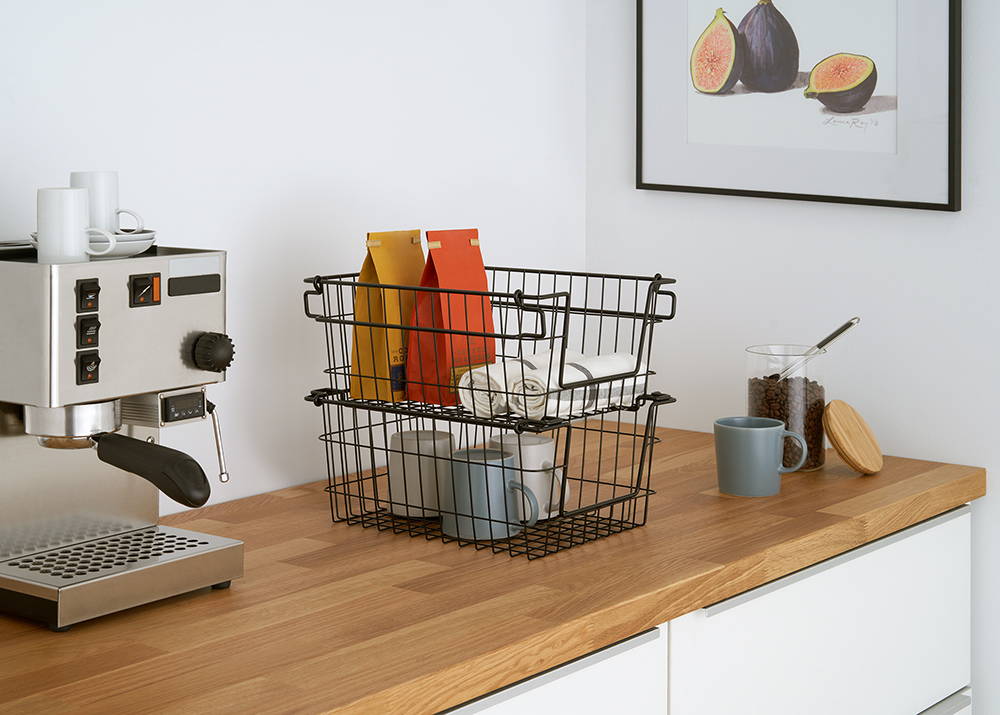 Stackable wire baskets on kitchen counter with items inside