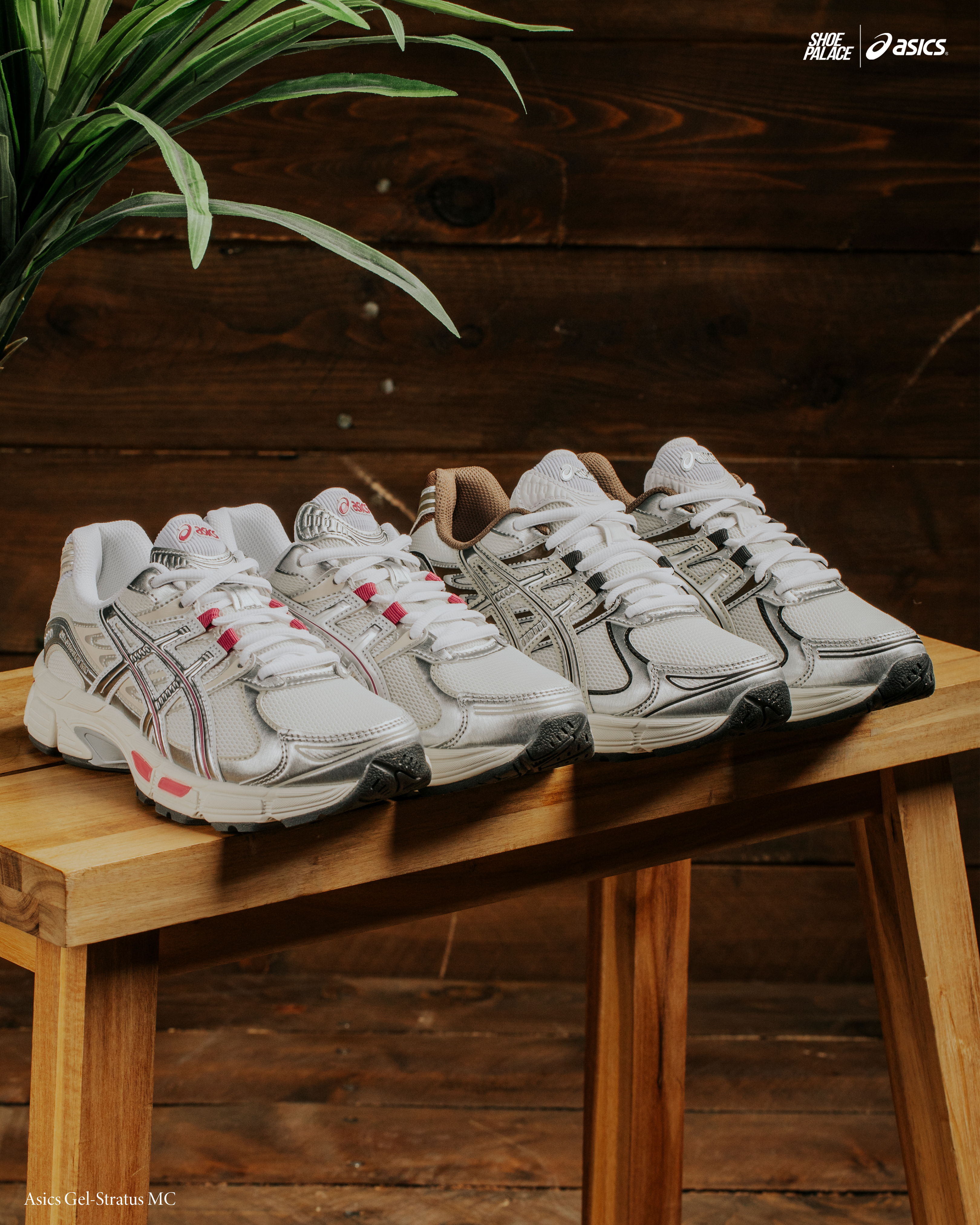 Three pairs of athletic shoes displayed on a wooden table with greenery.