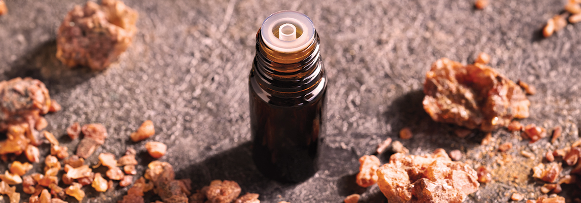 A small dark bottle surrounded by scattered brown material.