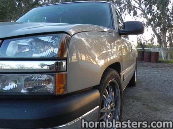 Front corner close-up of Thomas's silver 2005 Chevrolet Silverado 1500 with chrome wheel and headlight detail, install photo 4