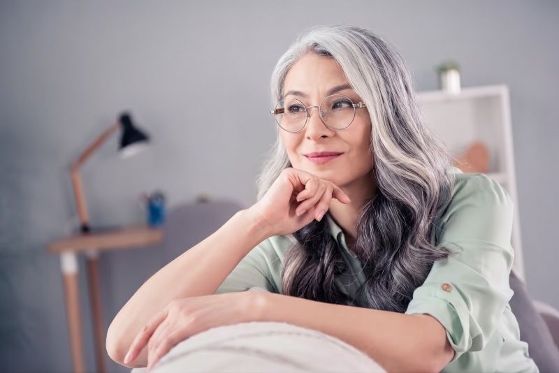 Woman with grey hair wearing Joy Silver round metal glasses
