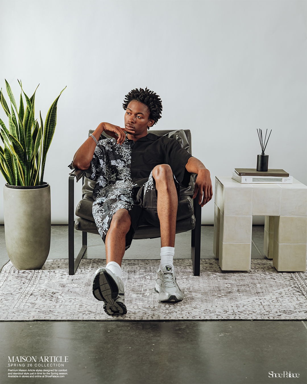 Person sitting in a chair, casual attire, indoor setting with plants.