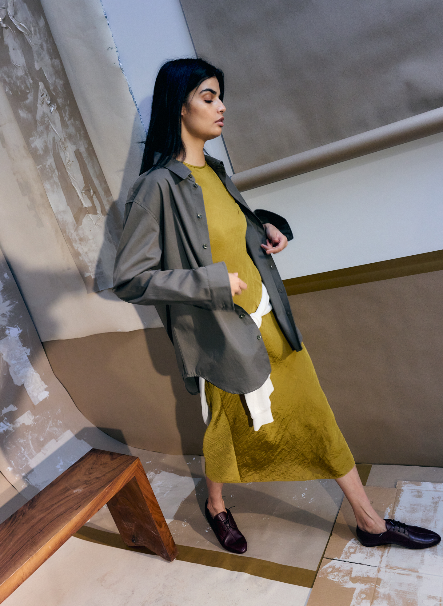Model in stylish outfit posing against a minimalist backdrop.