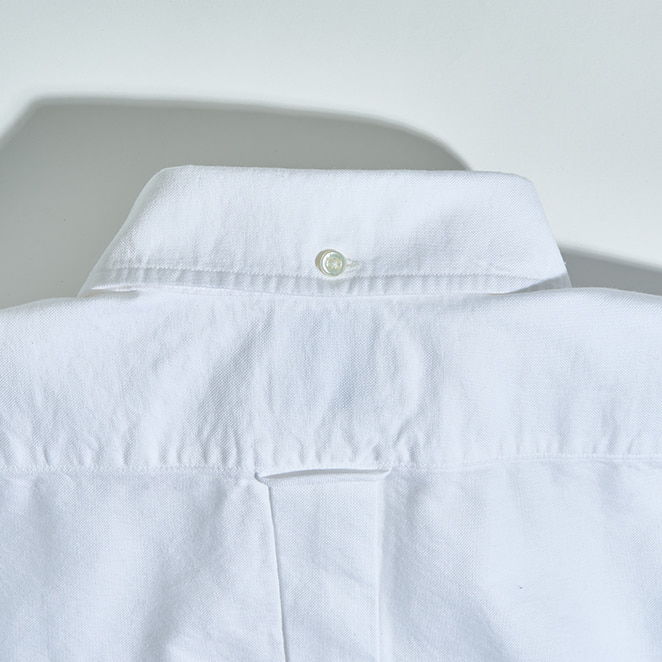 Back view of a white collared shirt.
