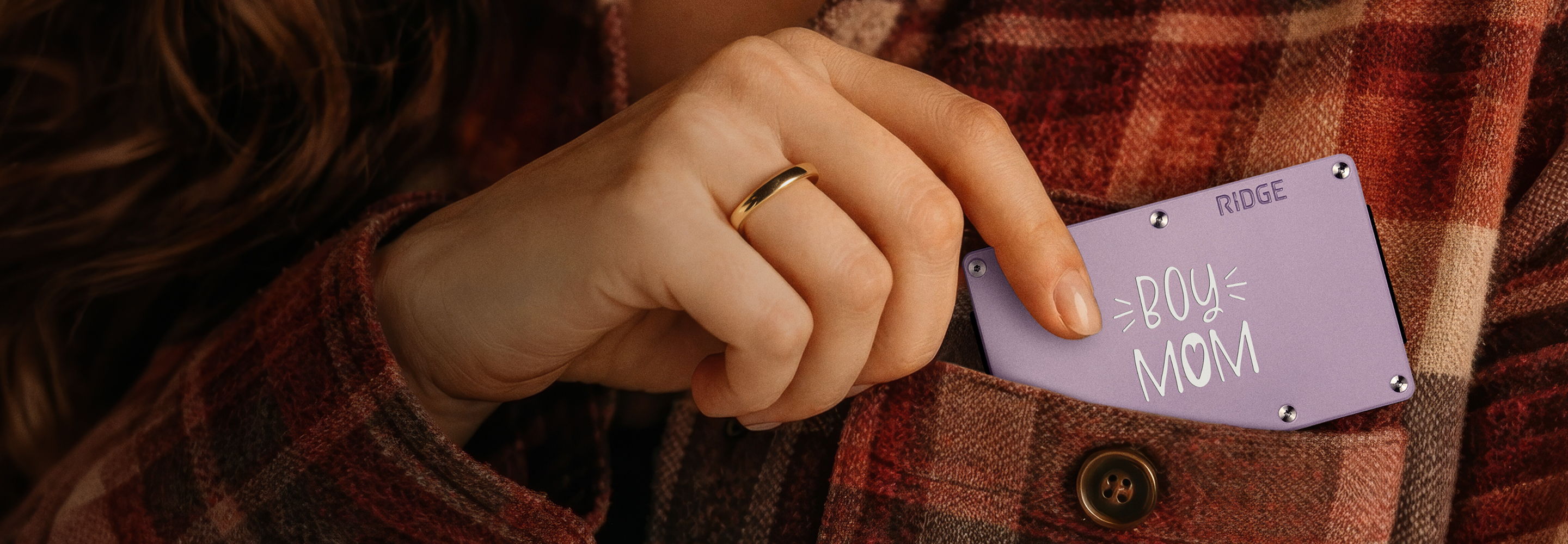 Person holding a purple card, wearing a plaid shirt.