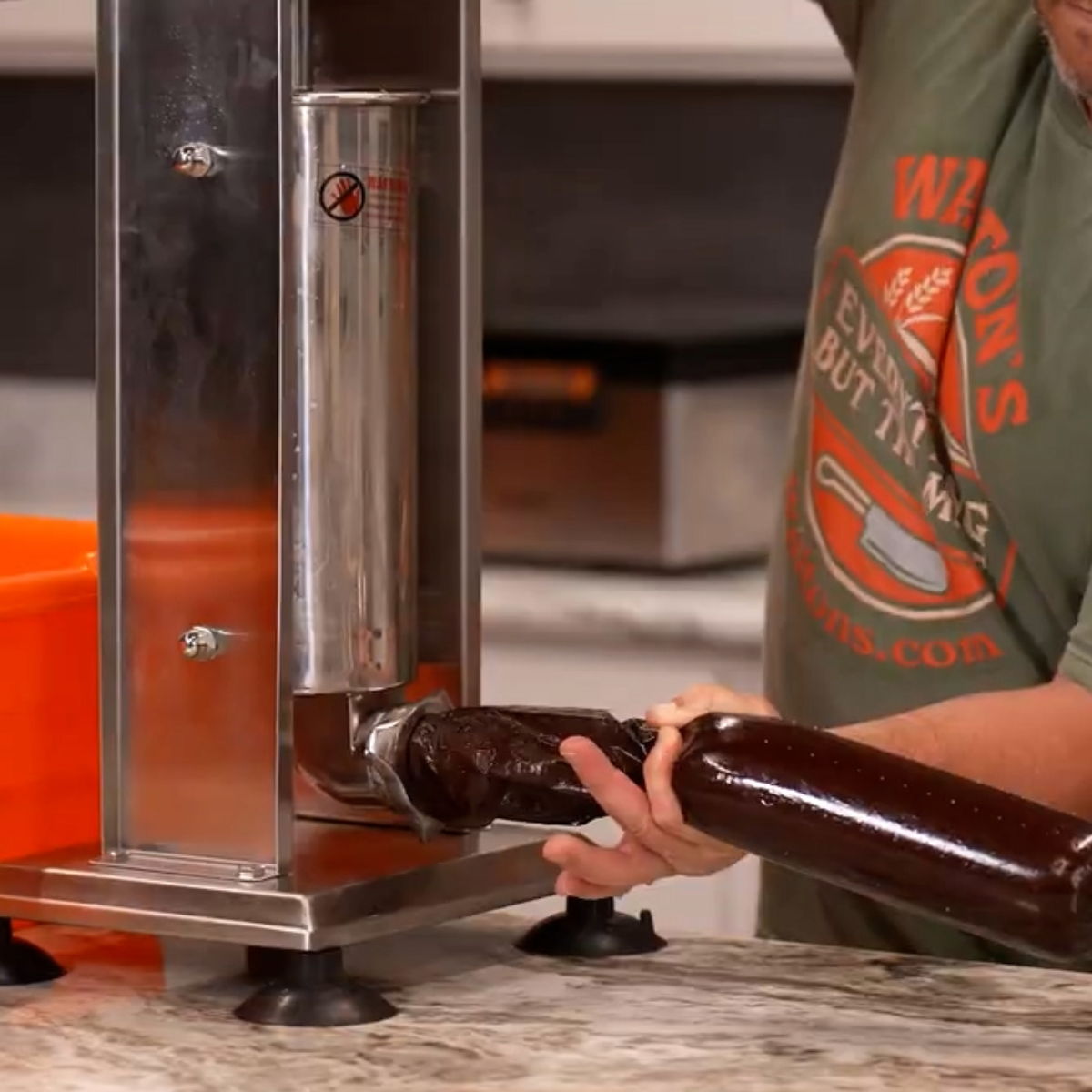 Person using a bottle filler on a countertop.