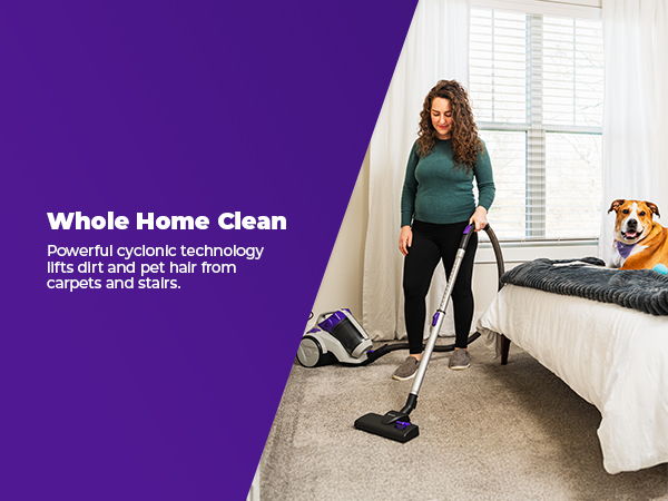 Woman vacuuming carpet with a dog nearby, promoting whole home cleaning technology.