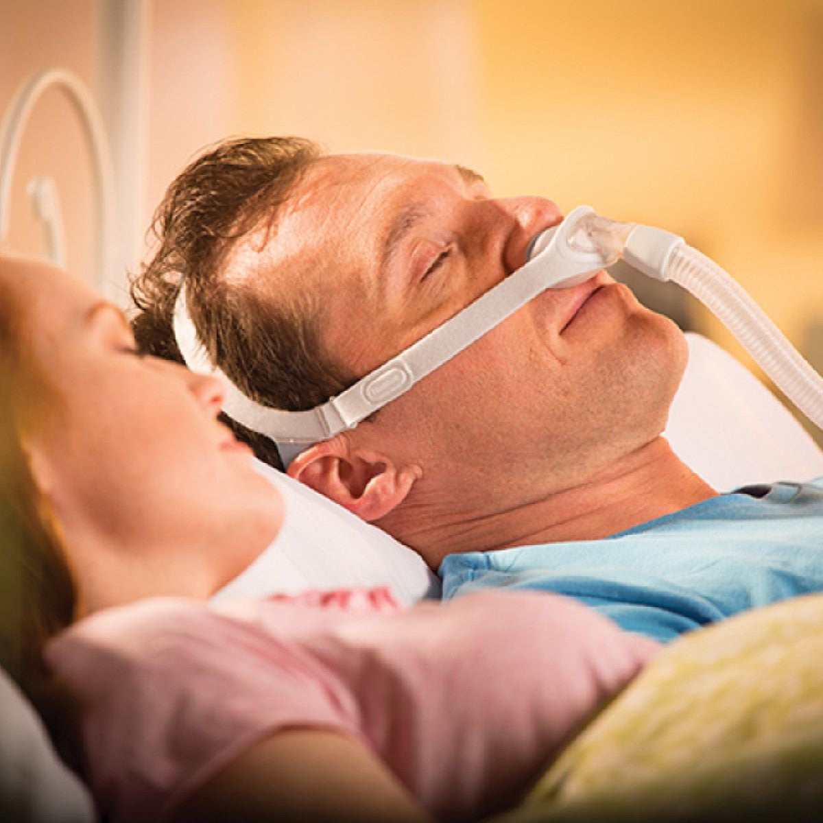 Photo of man using Philips Respironics Nuance Gel nasal pillow CPAP mask fit pack with headgear