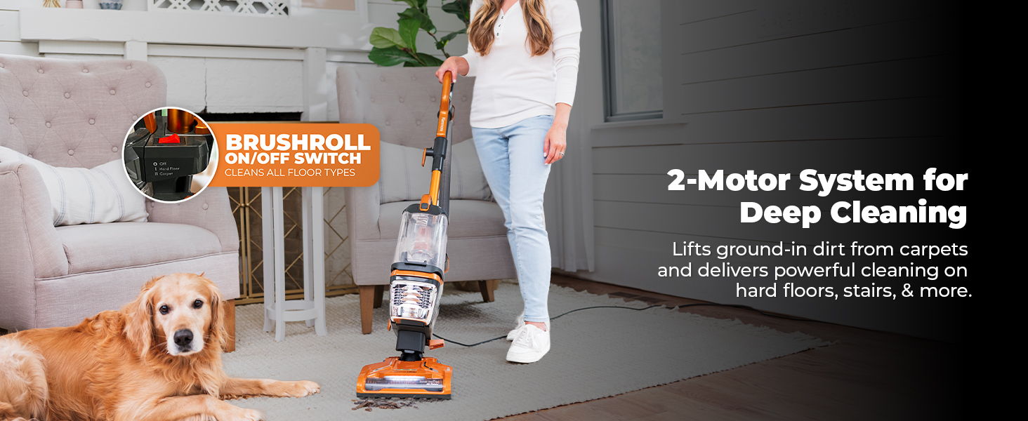 A woman using a vacuum cleaner near a dog in a living room.