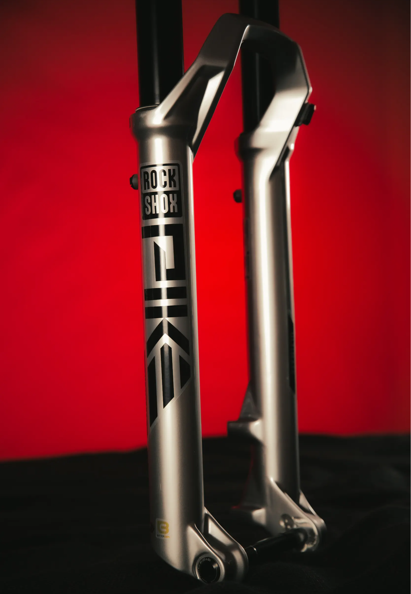 rockshox pike ultimate mountain bike fork in silver on a red and black background