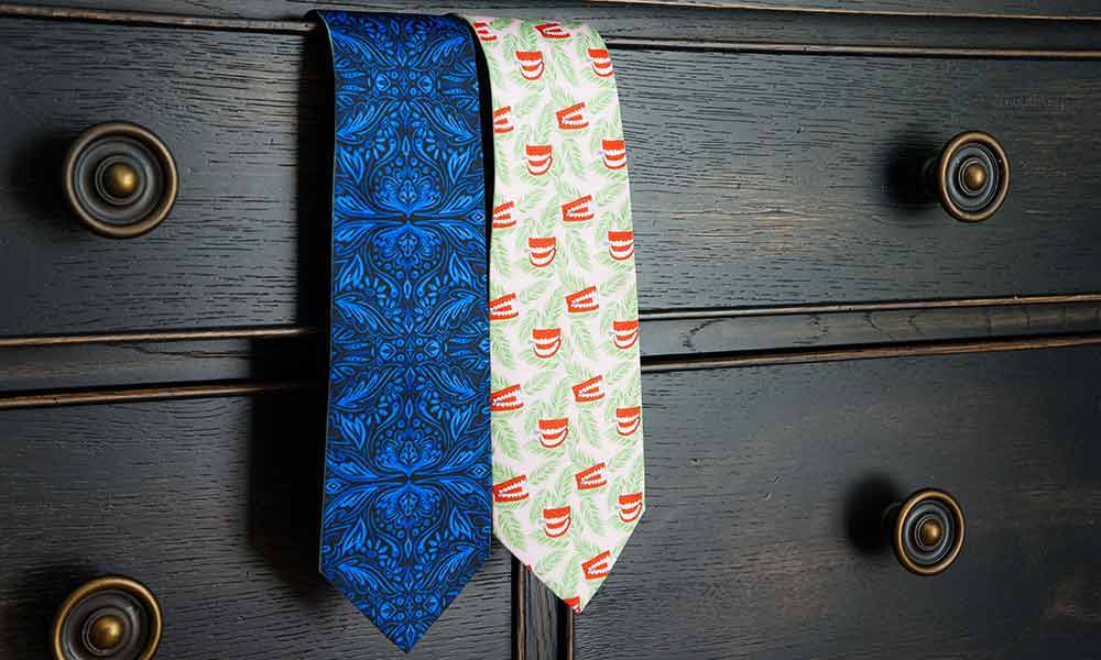 Two novelty pattern ties coming out of a dresser drawer