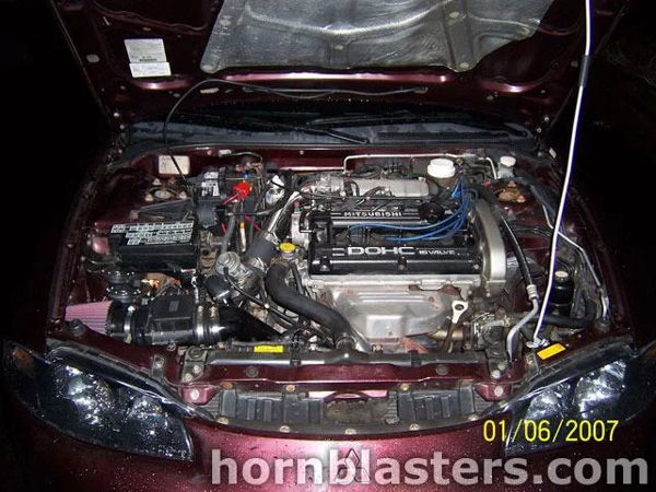 Engine bay Mitsubishi DOHC 16 valve pink intake air filter 1999 Eclipse Shocker XL train horn kit customer install gallery photo 3