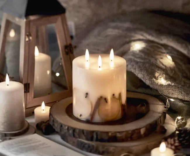 3 wick truglow winter candle surrounded by lantern and other candles
