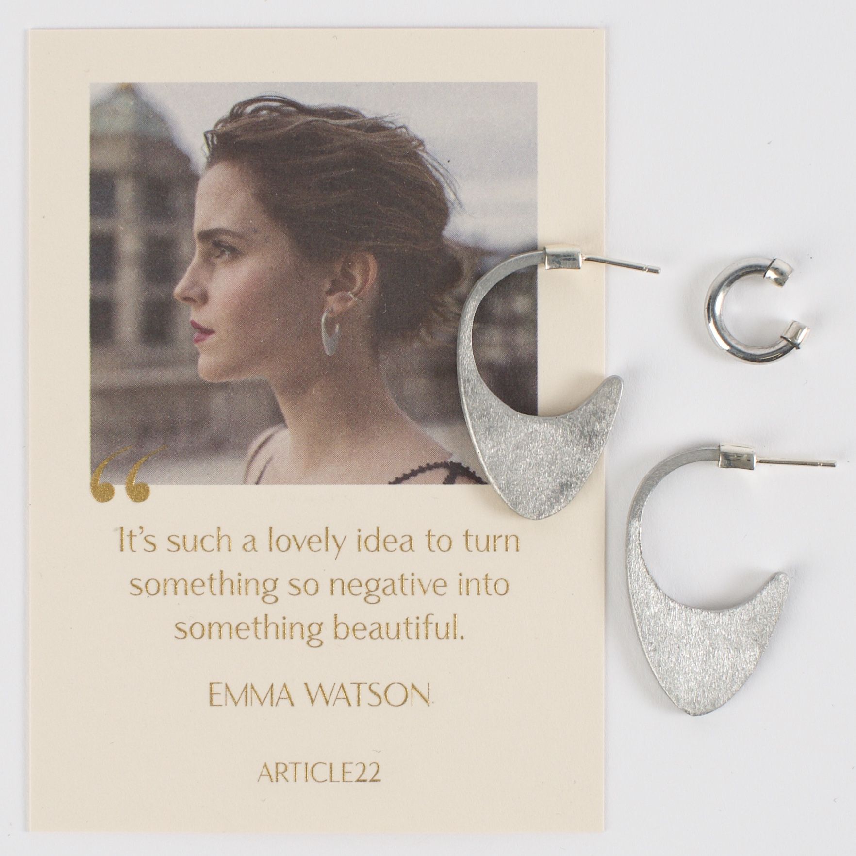Earrings displayed alongside a quote attributed to Emma Watson.