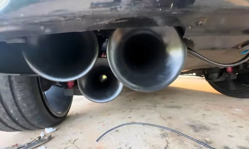 Under rear bumper close-up of triple Outlaw train horn bells mounted on 2000 Volkswagen Beetle gallery photo 3