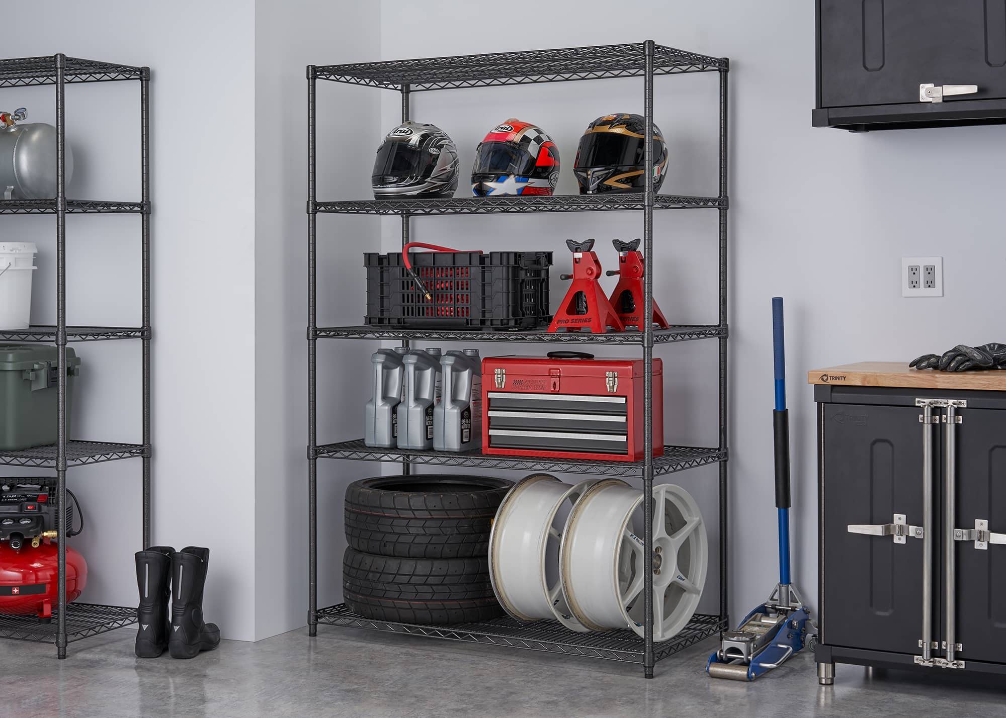 garage heavy duty wire shelving rack filled with spare tires and wheels and other motorsport items
