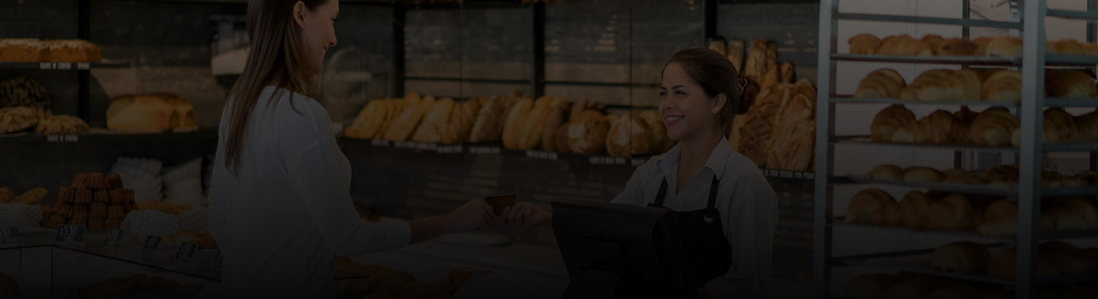 Bakery staff serving a customer at the counter, representing security and monitoring solutions for restaurants and food service businesses