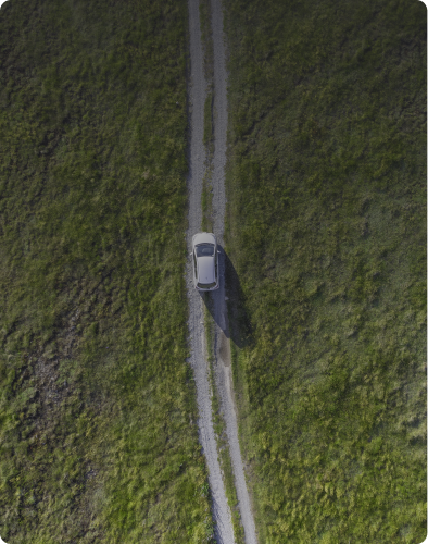 Aerial view of a car on a grassy path.
