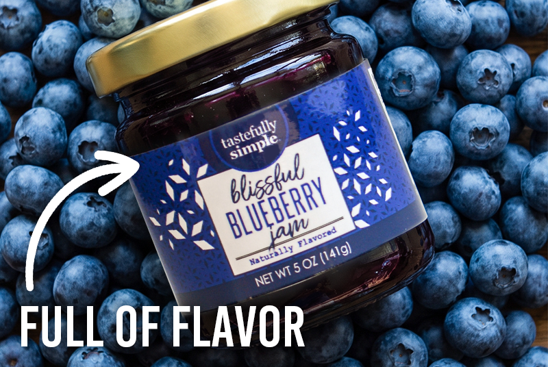 Tastefully Simple Blissful Blueberry Jam surrounded by fresh blueberries with the text 