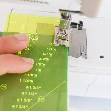 seam guide ruler on a sewing machine checking the seam allowance