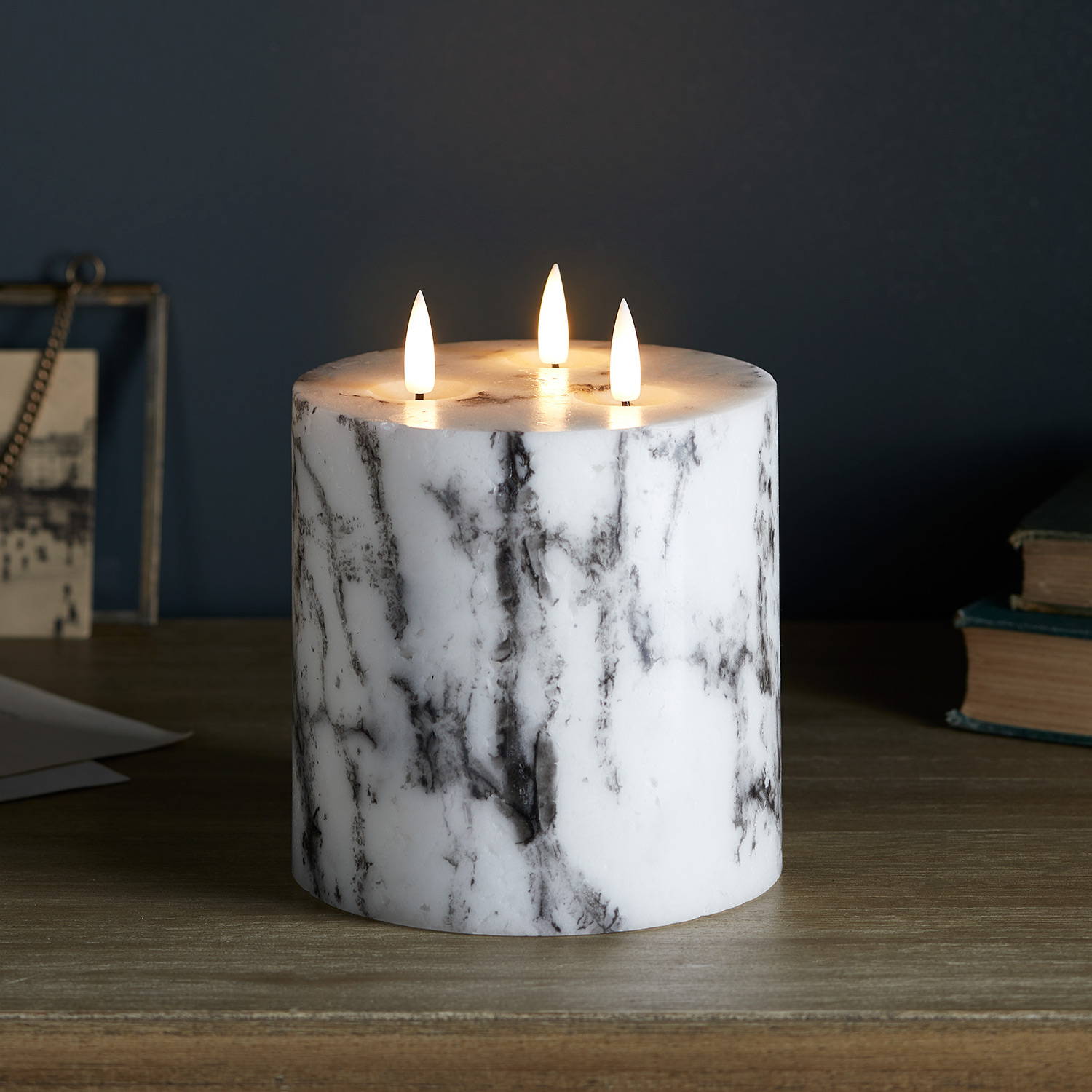 3 wick marble TruGlow candle illuminated on table