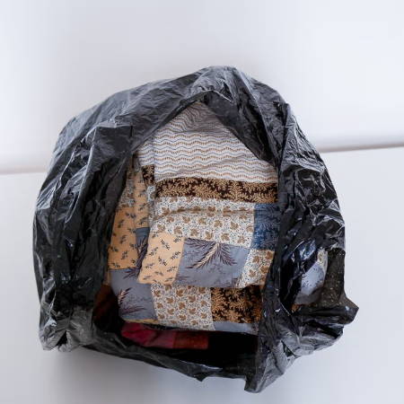 Quilts stored in a black plastic bag