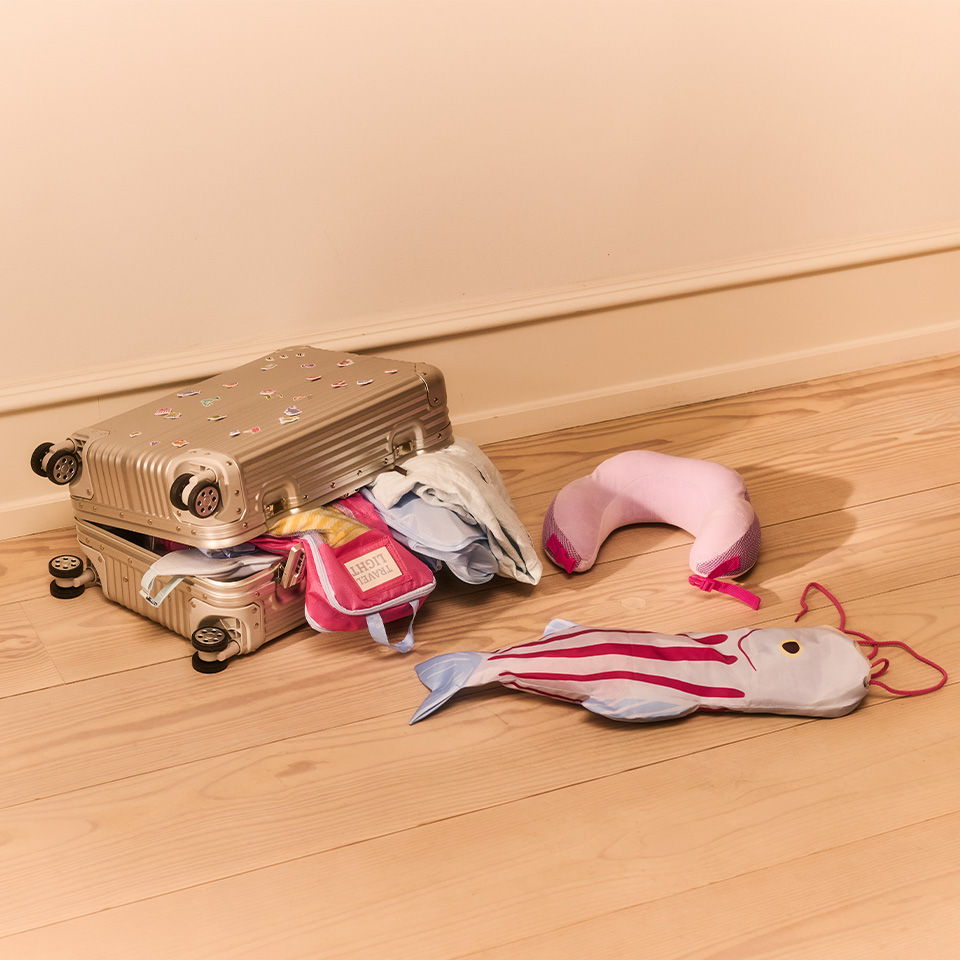 A suitcase with spilled stuffed toys on a wooden floor.