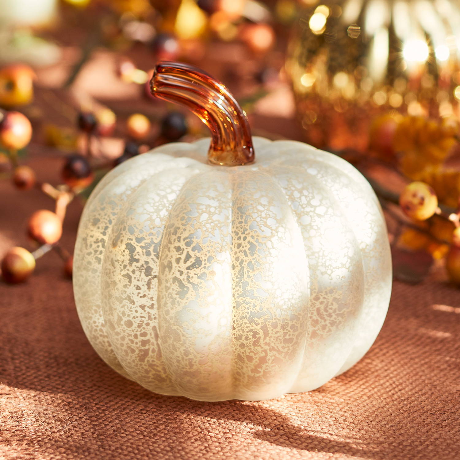 Antique white pumpkin decoration placed on an autumnal dining table