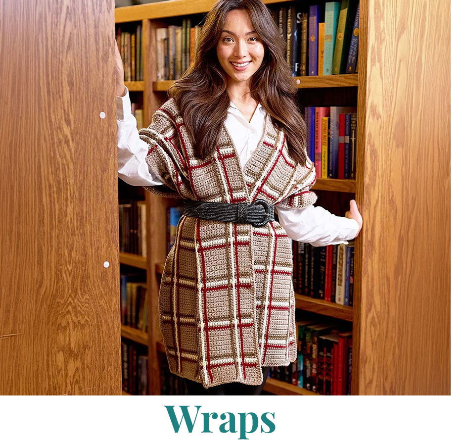 Woman in a stylish wrap standing in front of bookshelves.