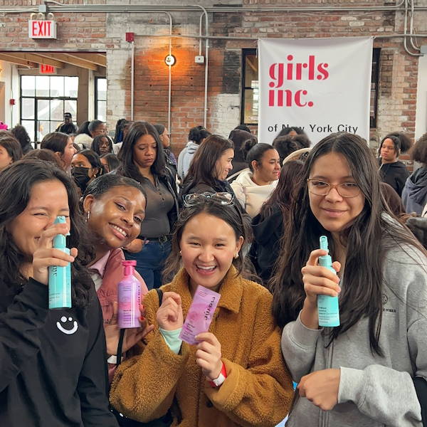 Girls holding Eva NYC hair care products
