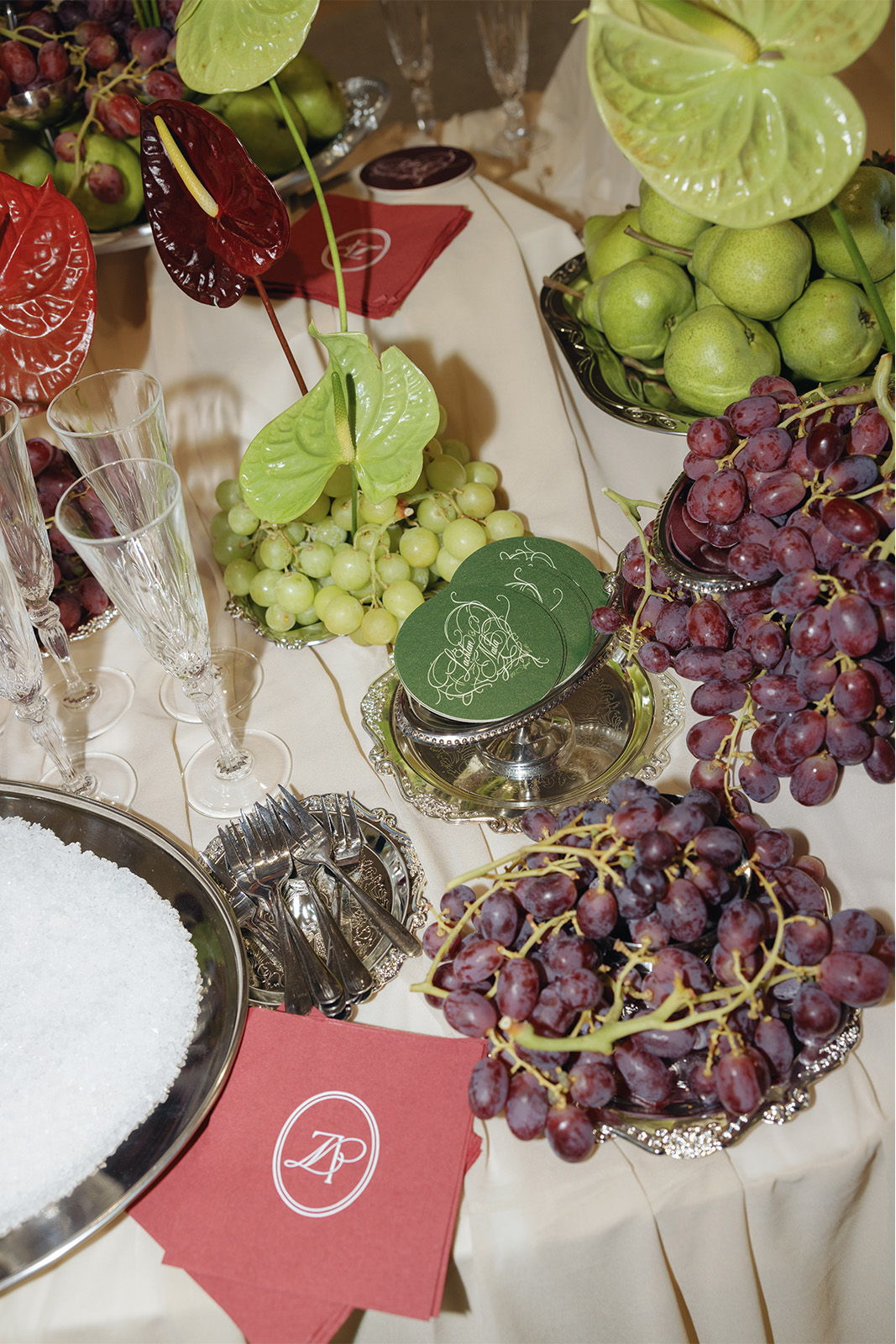 A table with various fruits, including grapes, apples, and decorative items.