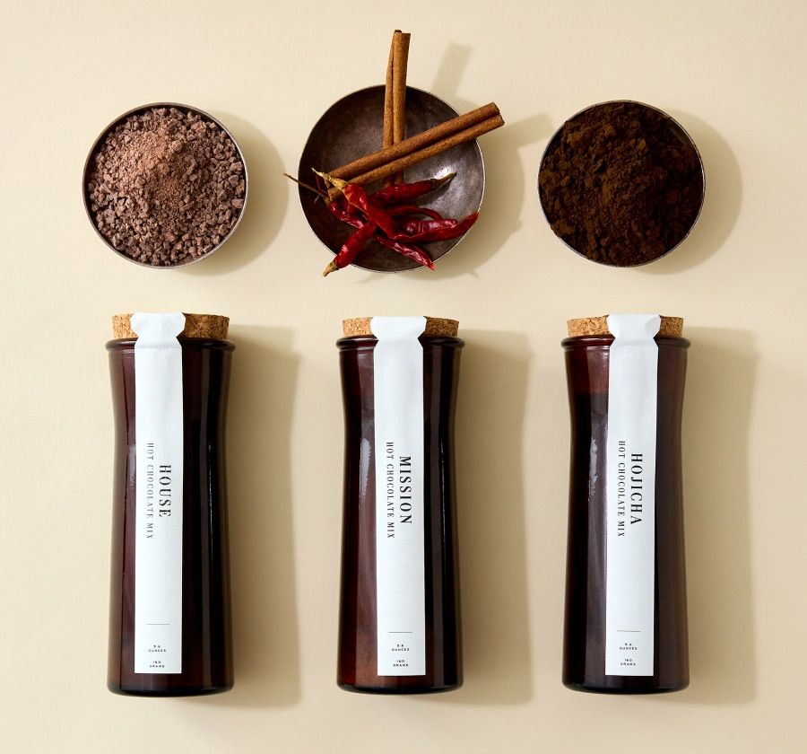 Three containers with spices and powders on a neutral background.