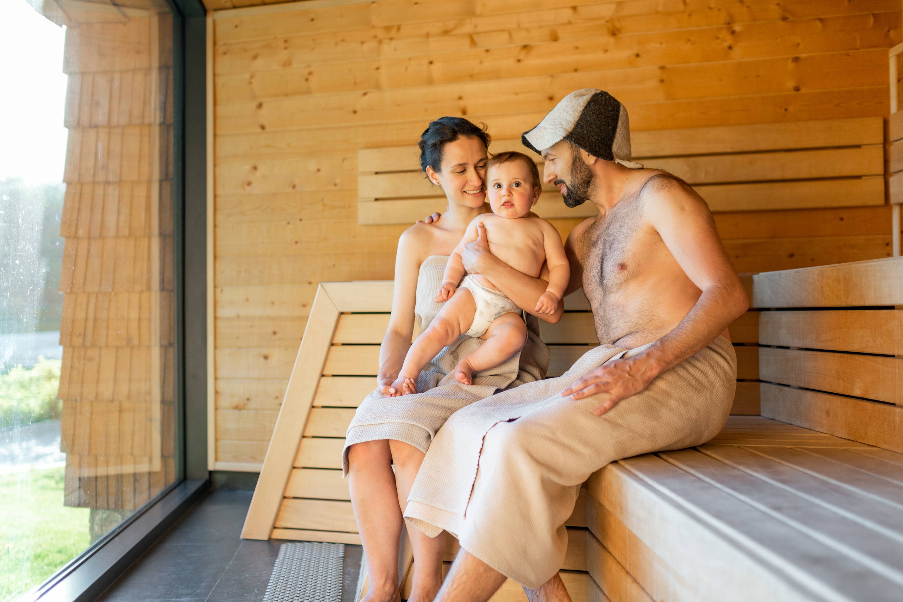 Couple with a baby in a sauna