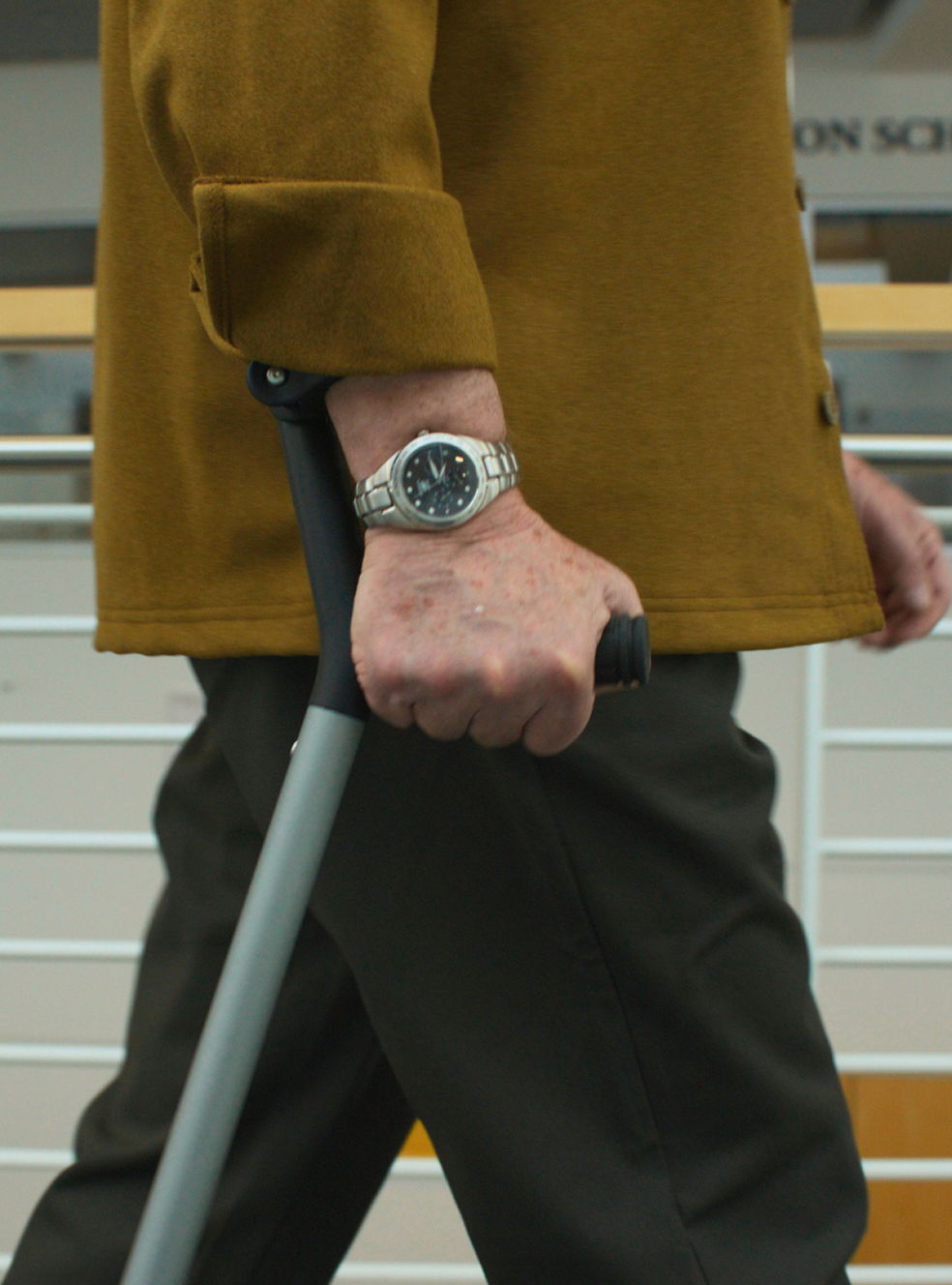close-up of a man's hand gripping the Y-Cane handle with wrist cuff support while walking
