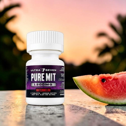 Bottle of Pure Mit supplement next to a watermelon slice at sunset.
