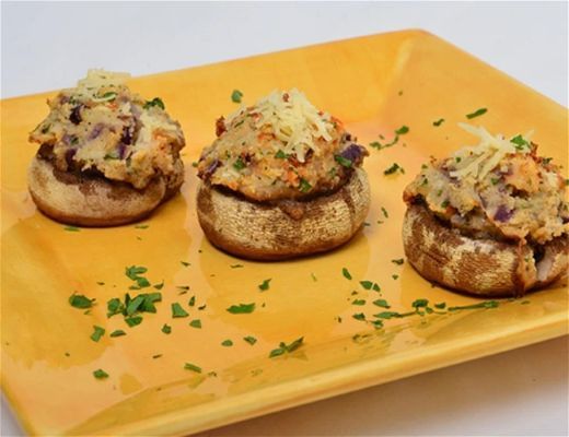 Stuffed mushrooms on a yellow plate with green garnish.