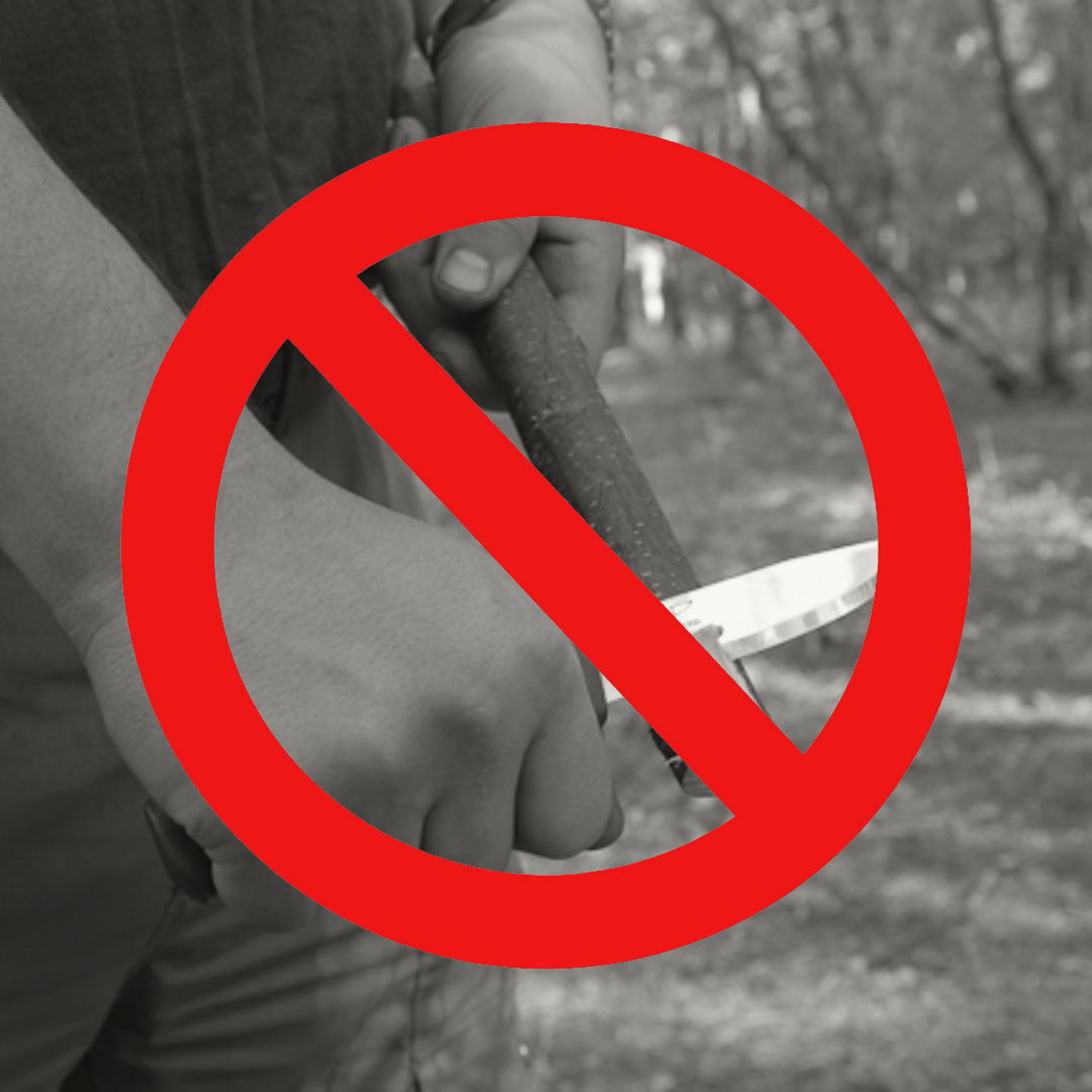 Hands holding a knife with a red 'no' symbol over it.